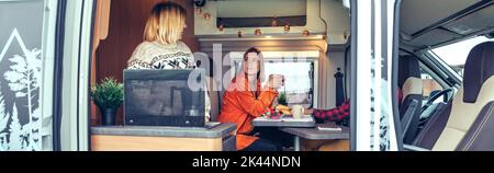 Friends having breakfast in a camper van in the morning Stock Photo