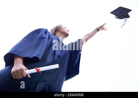 I did it. A graduate throwing his graduate hat in the air while holding his diploma. Stock Photo