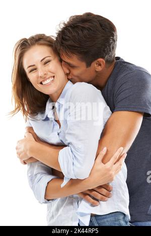 Young love. A happy young couple embracing against a white background. Stock Photo