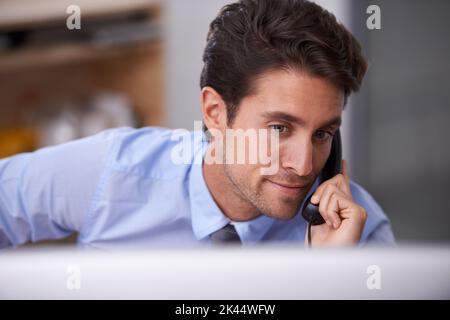Thats pleasant news. a handsome young businessman talking on the phone. Stock Photo