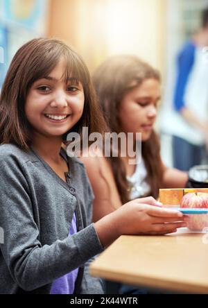 Cant to see what lunch Mom packed. Portrait of young school children eating lunch at school. Stock Photo