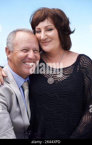 They fulfill each others lives. A mature woman sitting on her husbands lap and smiling happily. Stock Photo