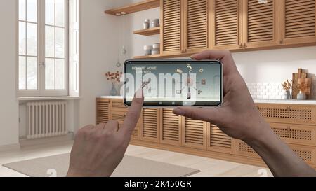 Remote home control system on a digital smart phone tablet. Device with app icons. Interior of country wooden kitchen, cabinets with shutters in the b Stock Photo