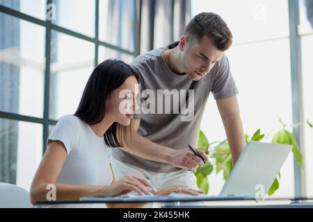 male ceo executive manager mentor giving consultation on financial operations to female colleague using laptop Stock Photo
