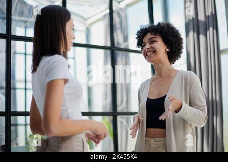 female employees enjoying break. Two women in formal clothes sitting in office lounge Stock Photo