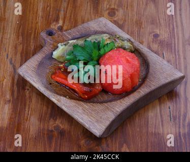 Canned tomatoes and cucumbers on wooden background Stock Photo