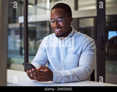 Black businessman, phone and networking in night office with digital marketing schedule, social media calendar and crm app. Smile, happy or motivation Stock Photo