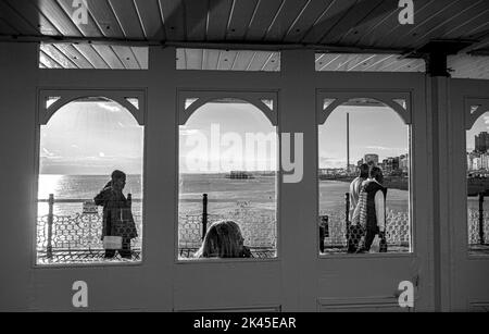 Visitors enjoy walking along Brighton Palace Pier on a late Autumn afternoon in sunshine , Sussex , England UK Stock Photo