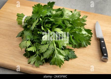 Bunch of fresh green celery leaves on a cutting board close up Stock Photo