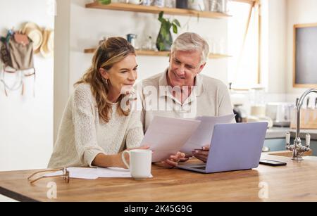 Retirement, finance and couple with budget on laptop satisfied with home expenses in New Zealand. Happy, positive and married senior people checking Stock Photo