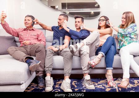 group of friends on couch takes a selfie in a funny way Stock Photo