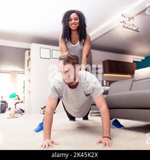 young couple having fun doing gymnastics at home Stock Photo