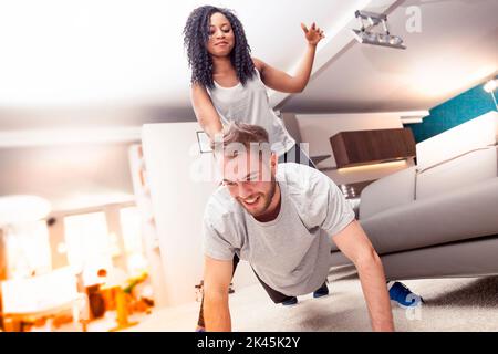 young couple having fun doing gymnastics at home Stock Photo