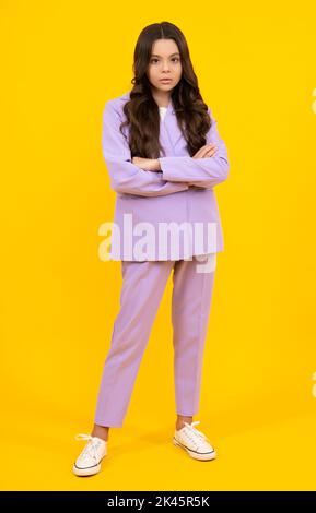 Full length of pretty cheerful teenager girl having fun good mood and posing in casual clothes isolated over yellow background. Stock Photo