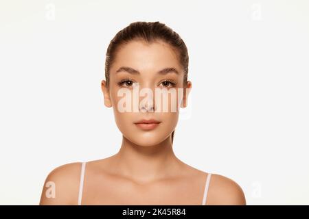 Portrait of young beautiful woman with clear spotless skin isolated over white background. Natural beauty Stock Photo