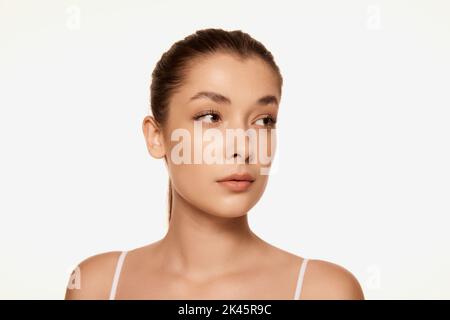 Portrait of young beautiful woman with clear spotless skin isolated over white background. No makeup look Stock Photo