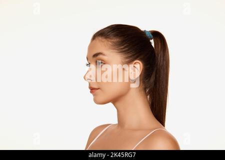 Portrait of young beautiful woman with clear spotless skin isolated over white background. Perfect face shape. Stock Photo