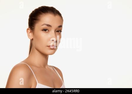 Portrait of young beautiful woman with clear spotless skin isolated over white background. Natural cosmetics face care Stock Photo