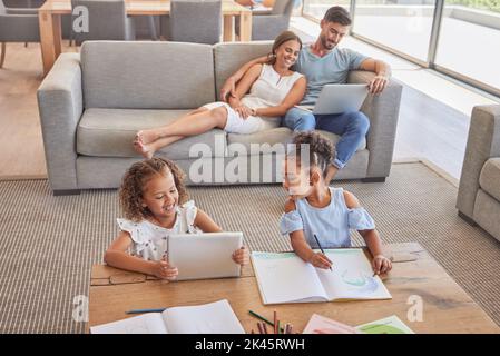 Family, children and education with a girl learning about art with a book and tablet in the living room with their parents. Kids, student and Stock Photo
