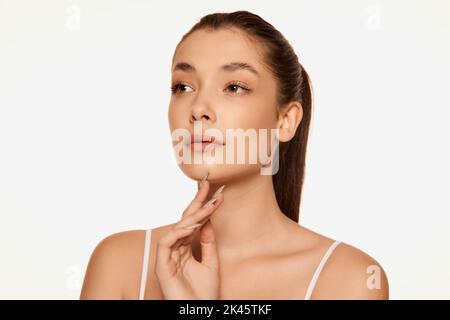 Portrait of young beautiful woman with clear spotless skin isolated over white background. Natural cosmetics care Stock Photo