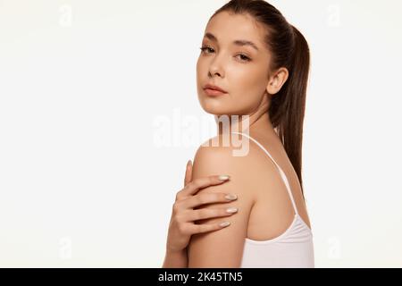 Portrait of young beautiful woman with clear spotless skin isolated over white background. Tenderness and wellness Stock Photo