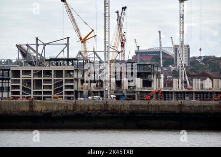 ongoing building works at Everton FCs new ground at bramley-moore dock liverpool uk with liverpool fc anfield main stand in the background Stock Photo