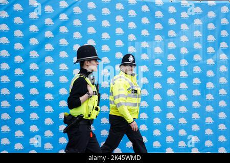 Police officers walk by Conservative Party signage in Birmingham ahead of the Conservative Party annual conference, which takes place at the International Convention Centre in the city next week. Picture date: Friday September 30, 2022. Stock Photo