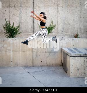 Sequence of Shots of Happy Young Black Woman Jumping Off a Walkway Stock Photo