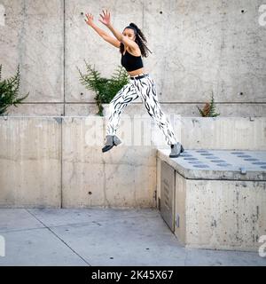 Sequence of Shots of Happy Young Black Woman Jumping Off a Walkway Stock Photo