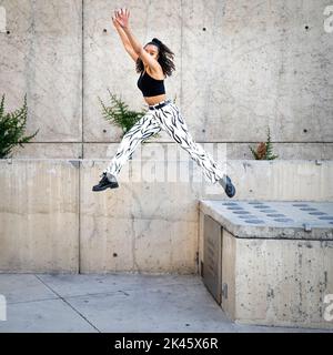 Sequence of Shots of Happy Young Black Woman Jumping Off a Walkway Stock Photo