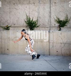 Sequence of Shots of Happy Young Black Woman Jumping Off a Walkway Stock Photo