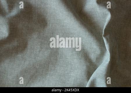 Abstract crumpled linen fabric texture background. Natural pale green color dyed linen organic eco textiles canvas background. Top view Stock Photo
