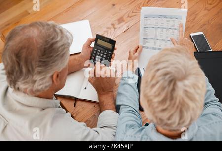 Budget, finance and senior couple with calculator planning financial investments, mortgage and tax papers. Elderly woman counting bills, debt and Stock Photo