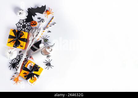 Happy Halloween holiday greeting card background. Flat lay gift boxes, set of Halloween symbols- spiders, bats, pumpkin, party decorations on white ba Stock Photo