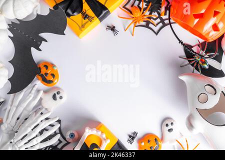 Happy Halloween holiday greeting card background. Flat lay gift boxes, set of Halloween symbols- spiders, bats, pumpkin, party decorations on white ba Stock Photo