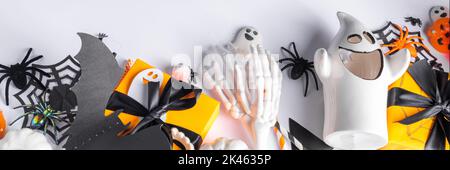 Happy Halloween holiday greeting card background. Flat lay gift boxes, set of Halloween symbols- spiders, bats, pumpkin, party decorations on white ba Stock Photo