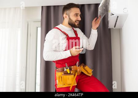 technician service checking and repairing air conditioner indoors. Stock Photo