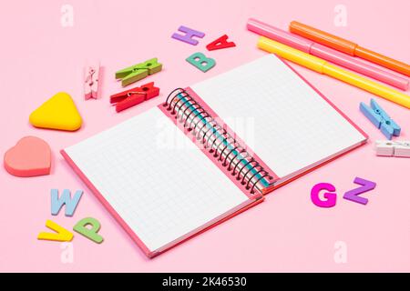 Open graph notebook and school utensils on a pink background Stock Photo