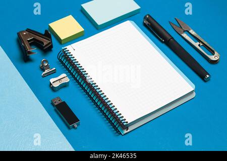 Open graph paper notebook and student utensils on a blue background Stock Photo