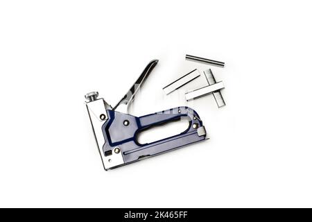 A blue stapler gun and staples on a white background with copy space Stock Photo