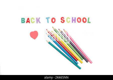 Back to school write with colored wooden letters and colored pencils on a white background Stock Photo