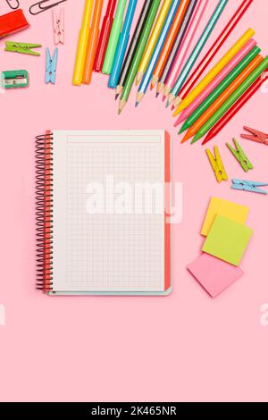 Blank open graph paper notebook and school utensils on a pink background with copy space Stock Photo