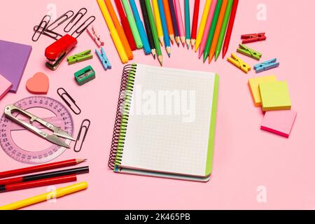Blank open graph paper notebook and school utensils on a pink background with copy space Stock Photo