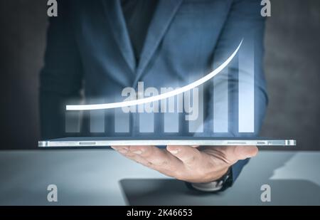 Businessman with report chart up forward to financial profit growth of stock market investment. Businessman holding digital tablet for provide access Stock Photo