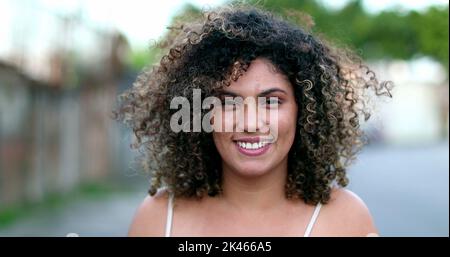 Happy Brazilian hispanic latina woman smiling to camera outside in street Stock Photo