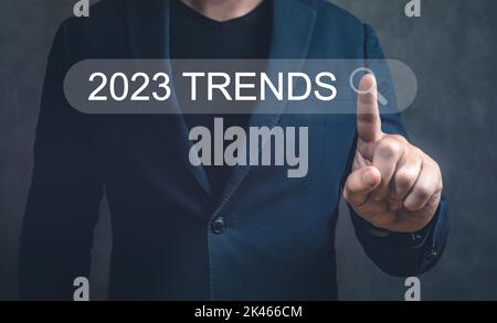 2023 trends search bar. Businesman hand touching 2023 trends search bar, banner, SEO, business trends planning. Man hand touching 2023 digital marketi Stock Photo