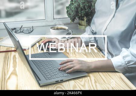 Webinar, Online training session or corporate online meeting. woman at desk at workplace preparing to watch webinar on laptop. digital technologies in Stock Photo