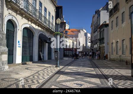 Aveiro, Portugal - August 14, 2022: View of street, Rua de Coimbra, in city center with motion-blurred tourists, street furniture, ornate buildings an Stock Photo