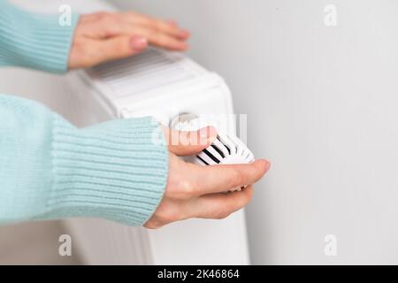 Woman's hand adjusting radiator temperature Stock Photo