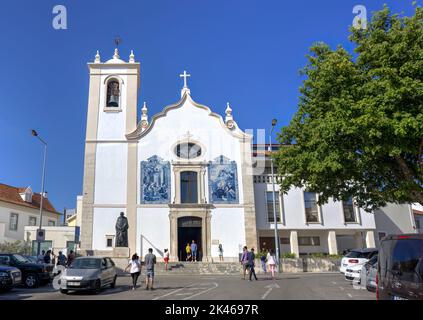 Aveiro, Portugal - August 14, 2022: Exterior of Vera Cruz church with parked cars and motion blurred pedestrians Stock Photo